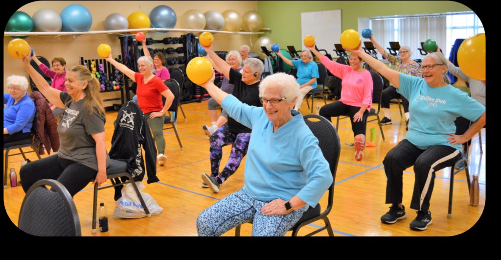 Older adults taking part in a seated group exercise class